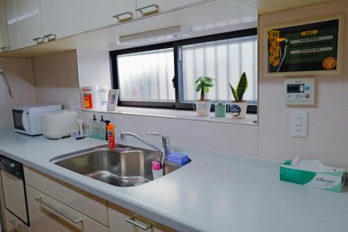 a kitchen counter with a sink and a window at Akira Hiro House - Room101 in Tokyo