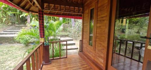 an open door of a wooden house with a porch at The Hidden Gem of Jembrana Bali in Mendaya