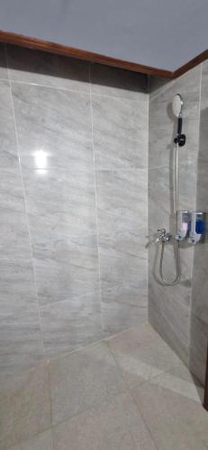 a shower in a bathroom with a tiled wall at The Hidden Gem of Jembrana Bali in Mendaya