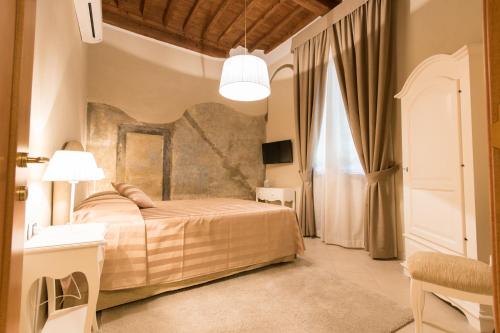 a bedroom with a bed and a large window at Residenza Marchesi Pontenani in Florence