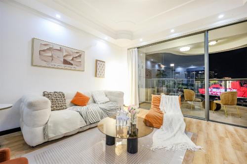 a living room with a couch and a table at Baihong Riverview Apartment-Hongya Cave in Chongqing