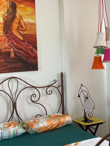 a bedroom with a bed with a painting on the wall at Little Pearl in Orikum