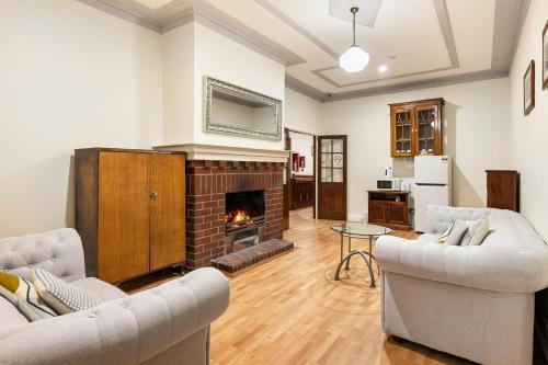 a living room with two couches and a fireplace at Canungra Hotel in Canungra