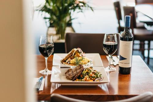 a table with a plate of food and two glasses of wine at Canungra Hotel in Canungra