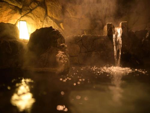 a pool of water in a cave with a waterfall at Eirakukan in Koriyama