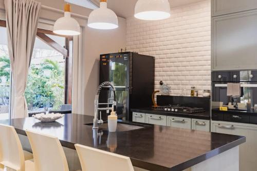 a kitchen with a black counter top and a black refrigerator at Villa Paradise - Blue Venao 3BR in Playa Venao