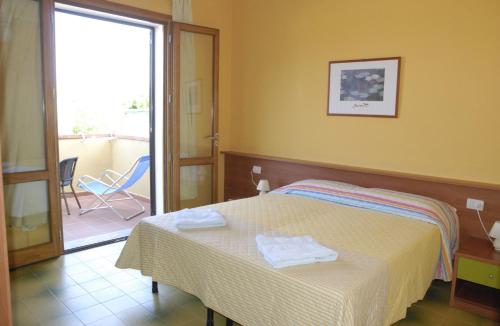 a hotel room with a bed and a balcony at B & B Summer in Marciana
