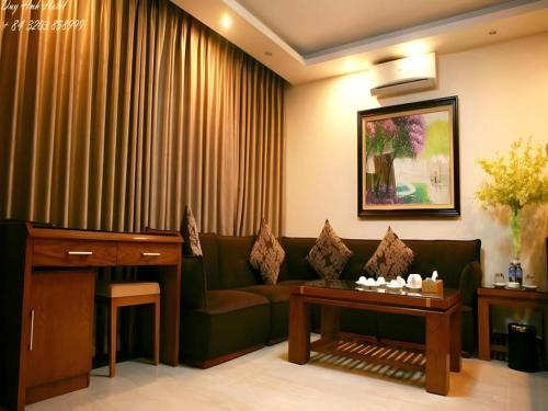 a living room with a green couch and a table at Duy Anh Hotel in Hải Dương