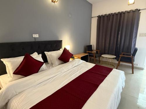 a bedroom with a large bed with red and white pillows at Moustache Hostel Bir in Bīr