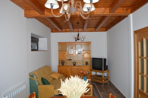 a living room with a couch and a tv at La Laguna in Hinojosa de la Sierra