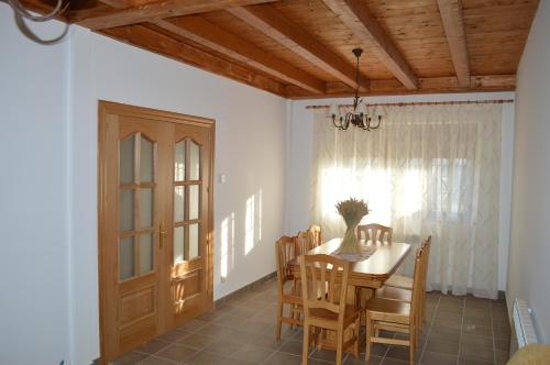 uma sala de jantar com uma mesa e cadeiras e uma porta em La Laguna em Hinojosa de la Sierra