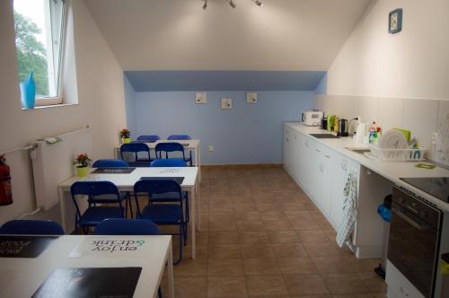 una cocina con encimeras azules y blancas y sillas azules en Smart Stay Hostel Gdynia, en Gdynia