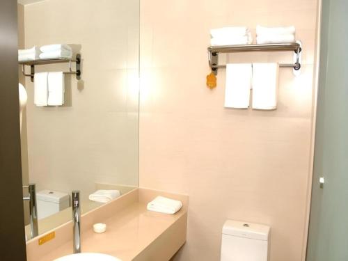 a bathroom with a sink and a mirror and a toilet at Jinjiang Inn Style Shenyang The Palace Huaiyuan Gate in Shenyang