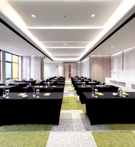a conference room with black tables and chairs at Somerset Queen City Semarang in Stasiun Tawang