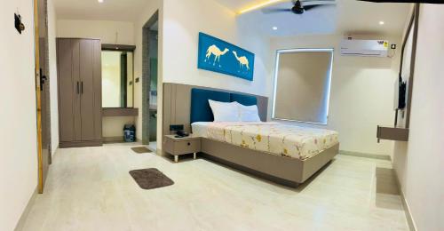 a bedroom with a bed with a blue wall at Hotel JMP in Khātu