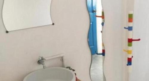 ein Bad mit einem WC und einem Wandspiegel in der Unterkunft The Sugar Hostel in Ban Sai Ma