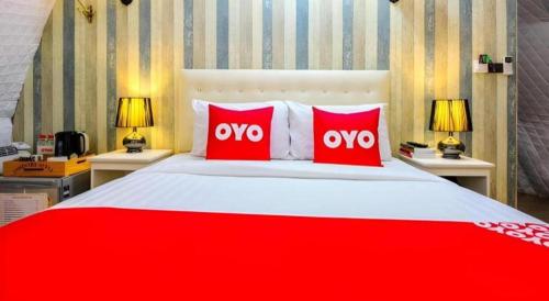 a large bed with red and white pillows on it at 5BOX Donmuang Airport in Bangkok