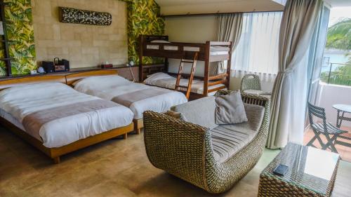 a bedroom with two beds and a chair at Sky Ocean - Ishigaki Eco-Resort - Newly Renovated in Ishigaki Island