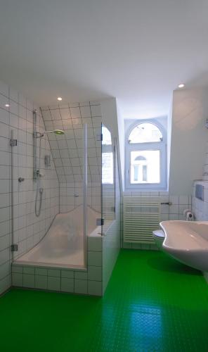 a bathroom with a shower and a tub and a sink at Apartment Essen- Bredeney in Essen