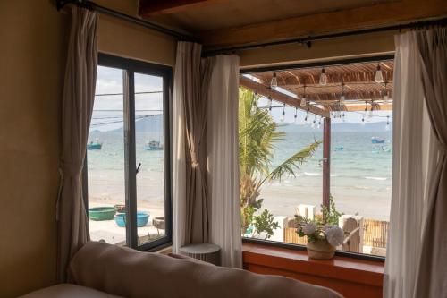 a bedroom with a view of the beach from a window at Ruby's Home- Doc Let's House 