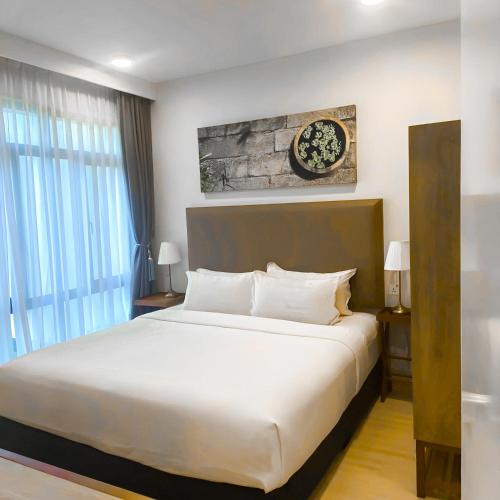 a bedroom with a large white bed and a window at Timurbay Residences in Kuantan