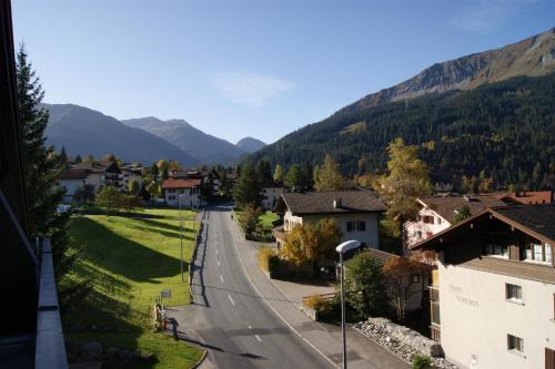 a street in a village with mountains in the background at Haus Euphrasia in Klosters