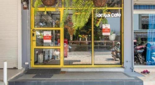 a yellow door of a store with a window at OYO 726 Sookjai Cafe and Hostel in Chiang Mai