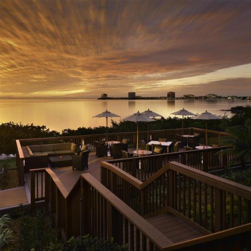 a restaurant with tables and umbrellas at sunset at Grand Hyatt Tampa Bay in Tampa