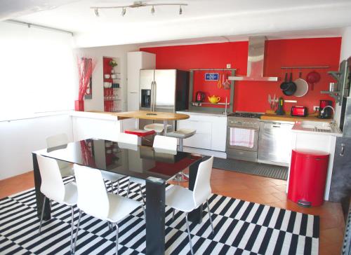 a kitchen with red walls and a table and chairs at Maison d'Elie in Saint-Tropez
