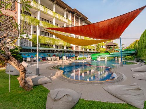 a resort with a pool with a slide at Prime Plaza Suites Sanur – Bali in Sanur