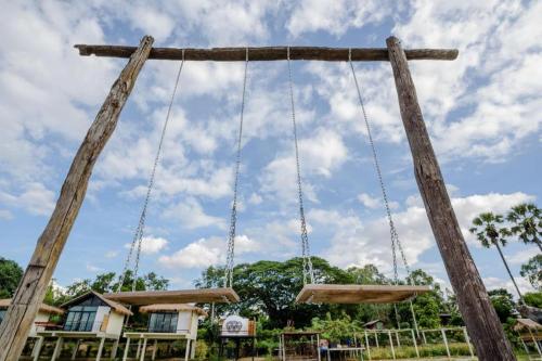 a swing at a park with a cloudy sky at Nornnadubua in Uthai Thani