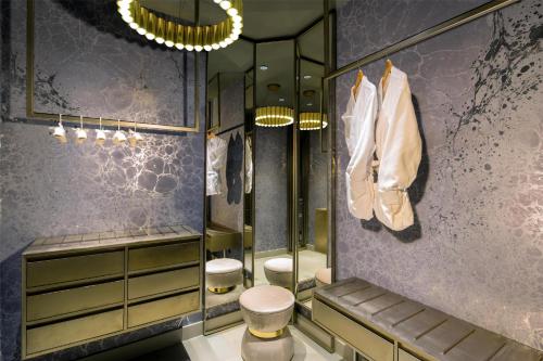 La salle de bains est pourvue de 2 toilettes et d'un mur violet. dans l'établissement The Time New York, part of JdV by Hyatt, à New York