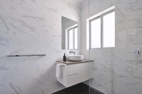 a white bathroom with a sink and a mirror at Rydges Resort Hunter Valley in Lovedale