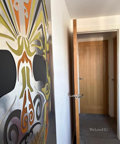a hallway with a painting of a mask next to a door at Boutique 1 Bedroom Duplex Suite on Marina-304 in Hull
