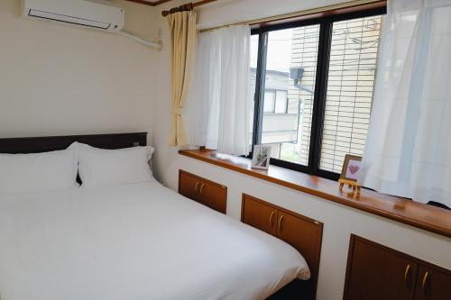 a bedroom with a large bed and a window at Akira Hiro House - Room102 in Tokyo