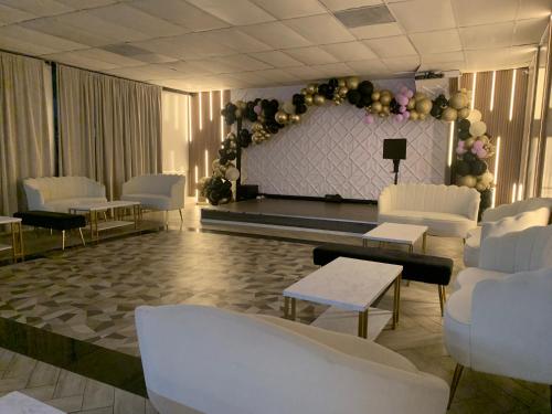 a room with white chairs and a stage with balloons at R Nite Star Inn and Suites -Home of the Cowboys & Rangers in Arlington