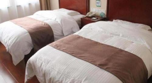 Ένα ή περισσότερα κρεβάτια σε δωμάτιο στο GreenTree Inn LiaoCheng LinQing HaiShan Building Express Hotel