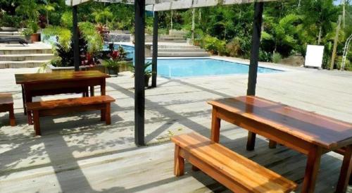 two picnic tables under an umbrella next to a swimming pool at Orator Hotel in Apia