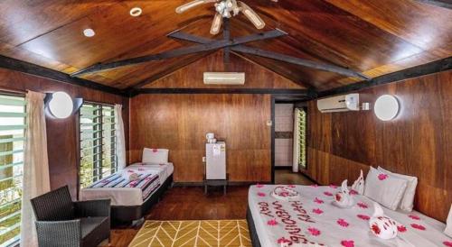 a room with two beds and a ceiling fan at Orator Hotel in Apia