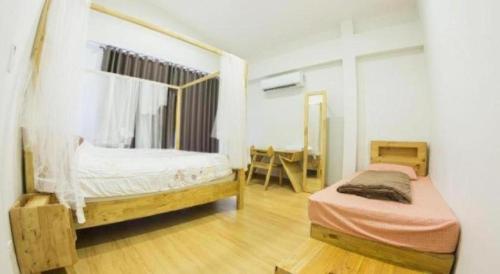a bedroom with two twin beds and a desk at Maximize Brand New Hostel Udonthani in Udon Thani