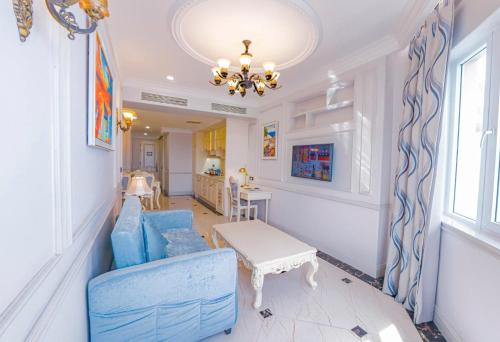 a living room with a blue couch and a table at Lan Rung Beach Resort in Long Hai