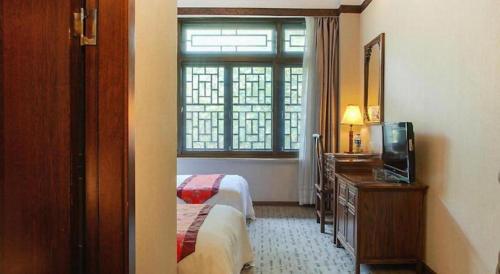 a hotel room with a bed and a window at James Joyce Coffetel Xian Dayanta Metro Station Branch in Xi'an