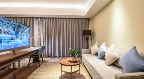 a living room with a couch and a flat screen tv at AURAYA BY SUNING NANJING XUZHUANG in Nanjing