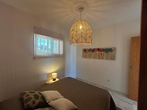 ein Schlafzimmer mit einem Bett und einem Kronleuchter in der Unterkunft Mirador at Island Resort in Sitio de Calahonda