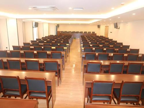 an empty lecture hall with desks and chairs at GreenTree Inn Yichun Mingyueshan Airport in Yichun