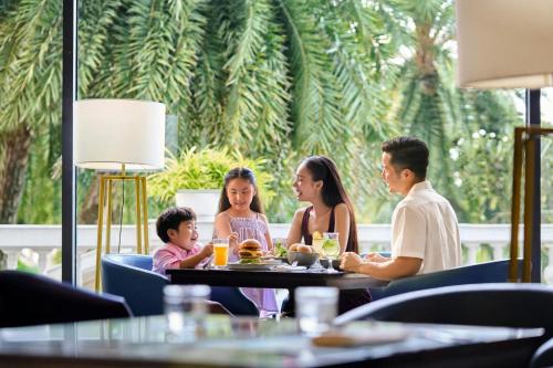 a family sitting at a table in a restaurant at Nha Trang Marriott Resort & Spa, Hon Tre Island in Nha Trang