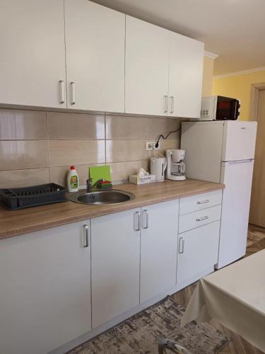 a kitchen with white cabinets and a sink at Casa O&A in Cristian