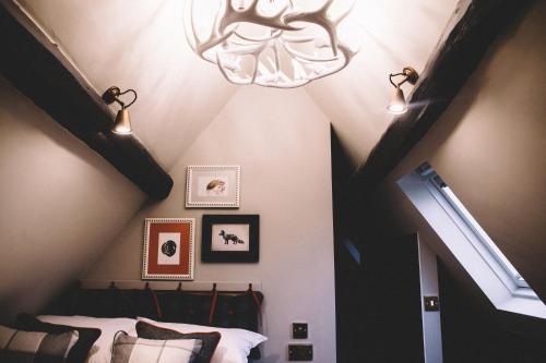 a bedroom with a ceiling with a chandelier and a bed at The Stag at Stow in Stow on the Wold