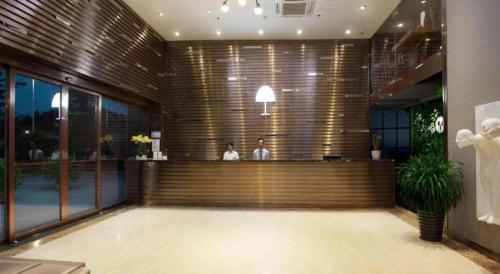 two people sitting at a bar in a building at The Art Hotel in Shenzhen
