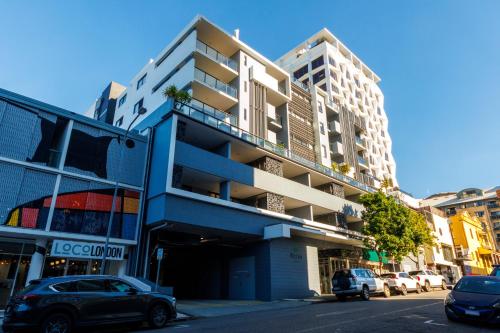 a building on a street with cars parked in front at Atrio Apartments in Brisbane